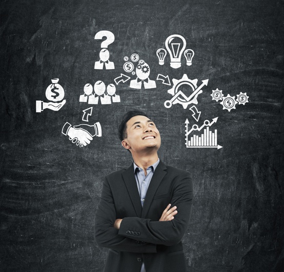 Asian man and business icons on blackboard